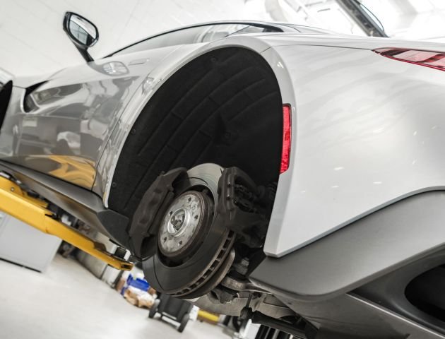 performance-car-on-automotive-lift-during-maintena-2023-11-27-05-20-33-utc-min